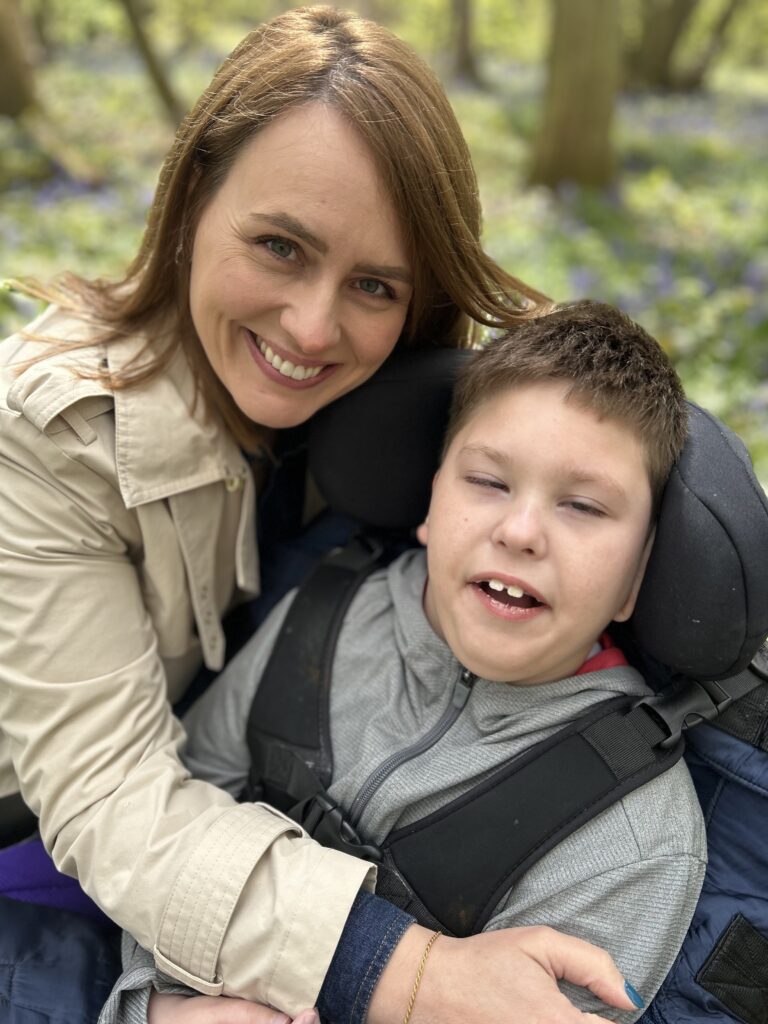 Hayley smiling with her son Harry in his wheelchair